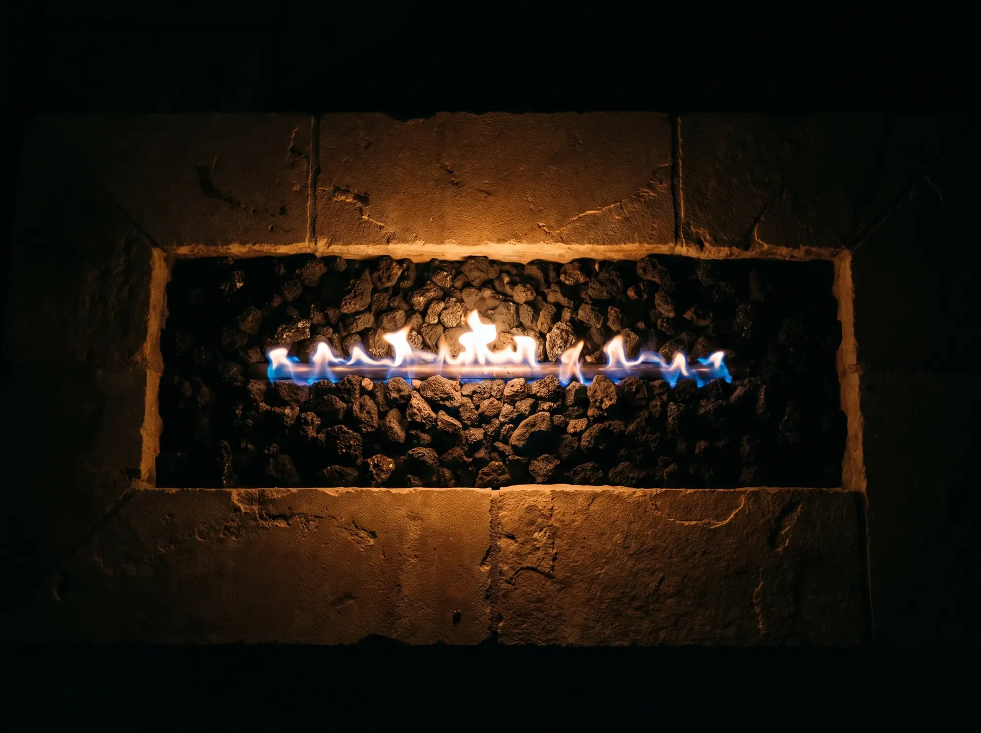 Gas fire pit burner with lava rock and a low flame